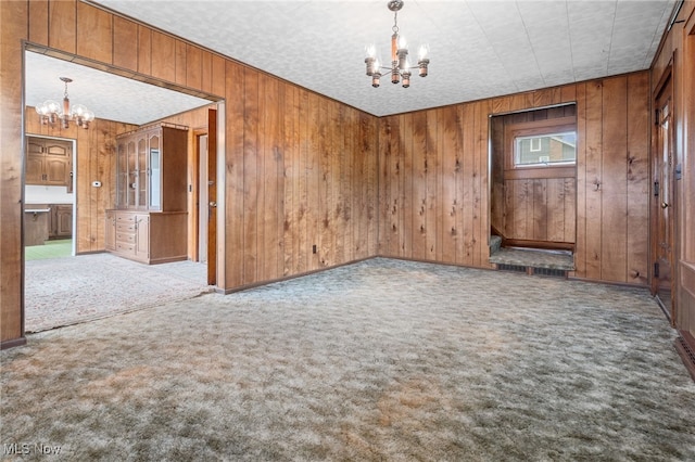 11861 Moffitt St SW, Massillon, OH 44647 - spare room featuring a chandelier, wooden walls, and carpet floors