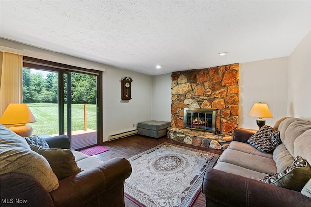 40698 Whitney Rd, Lagrange, OH 44050 - living area featuring wood finished floors, baseboard heating, a textured ceiling, a stone fireplace, and recessed lighting