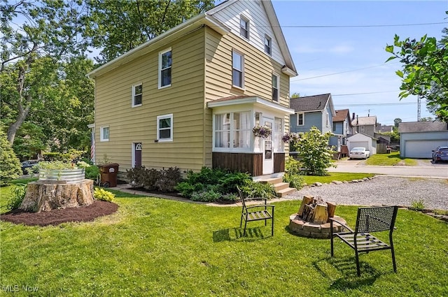 583 E 7th St, Salem, OH 44460 - view of side of property featuring a fire pit, a lawn, and entry steps