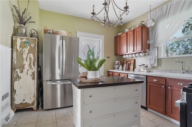 583 E 7th St, Salem, OH 44460 - kitchen with appliances with stainless steel finishes, light tile patterned flooring, a kitchen island, a chandelier, and dark countertops
