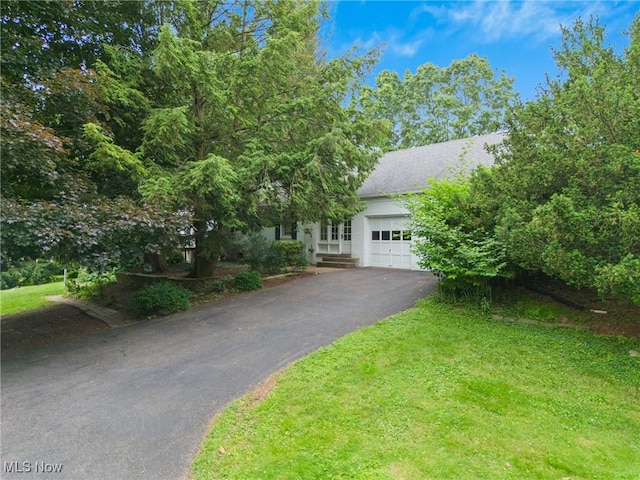 5352 Hills And Dales Rd NW, Canton, OH 44708 - obstructed view of property with an attached garage, asphalt driveway, and a front lawn