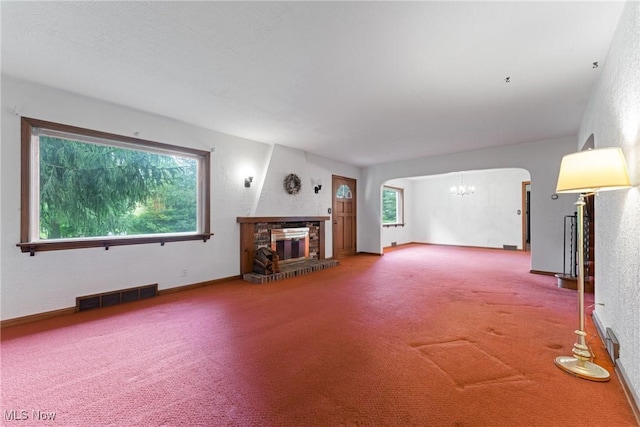 5352 Hills And Dales Rd NW, Canton, OH 44708 - carpeted living room with a chandelier, arched walkways, plenty of natural light, and a glass covered fireplace