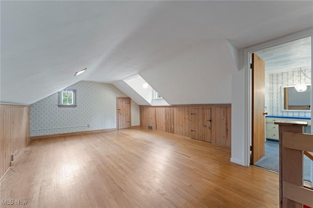 5352 Hills And Dales Rd NW, Canton, OH 44708 - additional living space with wallpapered walls, light wood-style flooring, and lofted ceiling