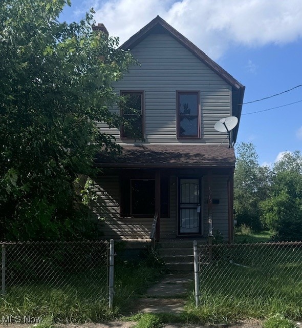 1015 4th St NW, Canton, OH 44703 - view of front of home featuring covered porch, a fenced front yard, and a chimney