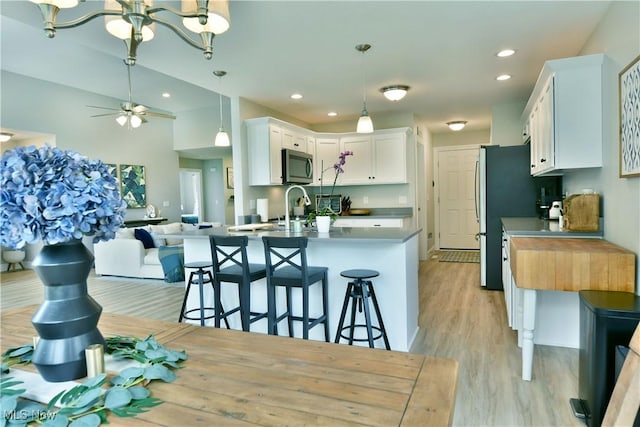 125 Fitch Blvd Unit 254, Youngstown, OH 44515 - kitchen featuring stainless steel microwave, open floor plan, light wood-type flooring, white cabinetry, and a ceiling fan