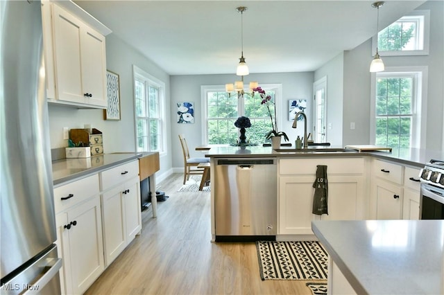 125 Fitch Blvd Unit 254, Youngstown, OH 44515 - kitchen featuring appliances with stainless steel finishes, light wood-style flooring, white cabinetry, and pendant lighting