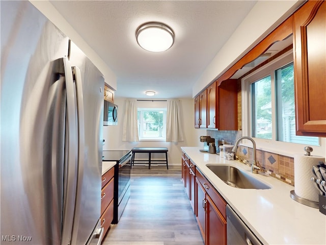 451 Edgewood Cir, Berea, OH 44017 - kitchen featuring appliances with stainless steel finishes, light countertops, light wood finished floors, and decorative backsplash
