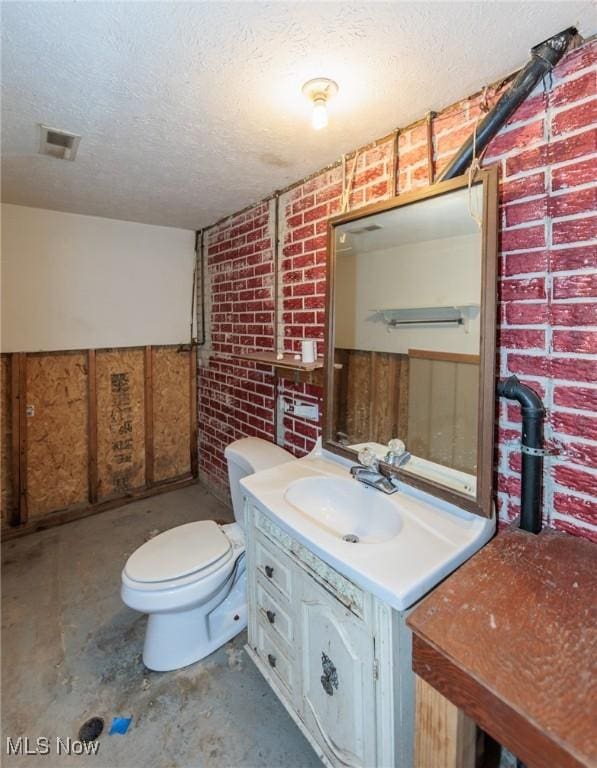 1730 W 20th St, Lorain, OH 44052 - half bath featuring a textured ceiling, vanity, unfinished concrete flooring, brick wall, and a wainscoted wall