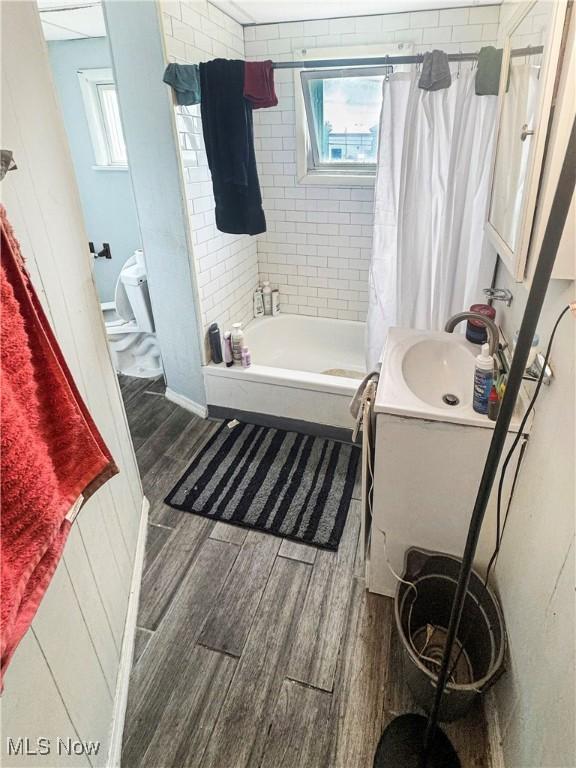 4017 E 54th St, Newburgh Heights, OH 44105 - full bathroom featuring healthy amount of natural light, wood finished floors, shower / tub combo, and vanity