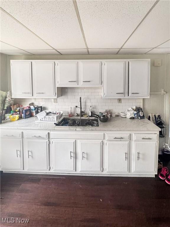 4017 E 54th St, Newburgh Heights, OH 44105 - kitchen with white cabinets, a paneled ceiling, light countertops, dark wood-type flooring, and decorative backsplash