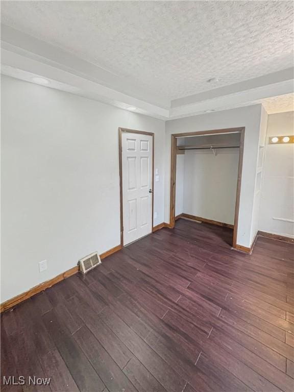 4017 E 54th St, Newburgh Heights, OH 44105 - unfurnished bedroom with dark wood-style flooring, a textured ceiling, and a closet