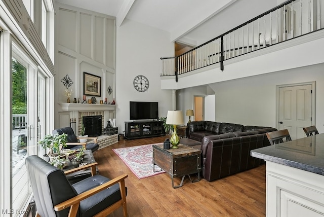 1497 Hunting Hollow Dr, Hudson, OH 44236 - living area featuring a high ceiling, beam ceiling, a fireplace, and light wood-style flooring