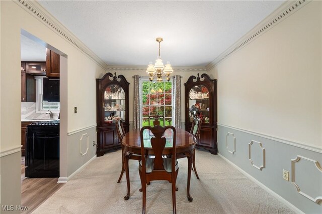 4270 Sir Robert Ave, North Royalton, OH 44133 - dining space with a chandelier, a wainscoted wall, crown molding, and light colored carpet