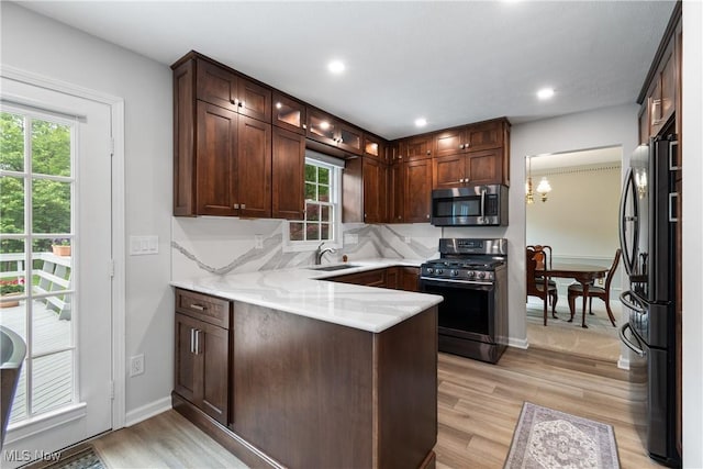 4270 Sir Robert Ave, North Royalton, OH 44133 - kitchen with stainless steel appliances, light wood-style floors, a peninsula, glass insert cabinets, and decorative backsplash