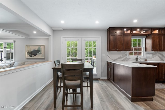 4270 Sir Robert Ave, North Royalton, OH 44133 - kitchen with light wood-style flooring, dark brown cabinets, recessed lighting, glass insert cabinets, and tasteful backsplash