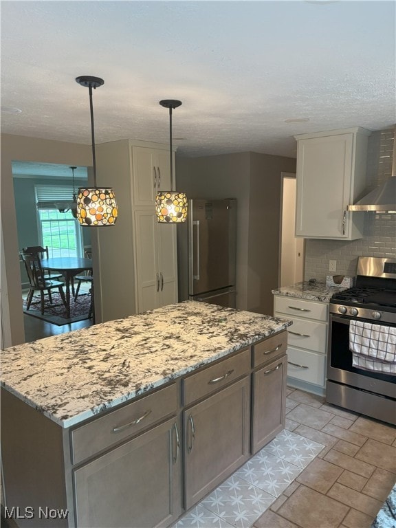 3611 Mark Dr, Broadview Heights, OH 44147 - kitchen with stainless steel appliances, wall chimney range hood, decorative backsplash, a center island, and light stone counters