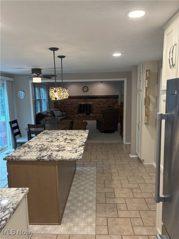 3611 Mark Dr, Broadview Heights, OH 44147 - kitchen with white cabinets, freestanding refrigerator, open floor plan, ceiling fan, and decorative light fixtures