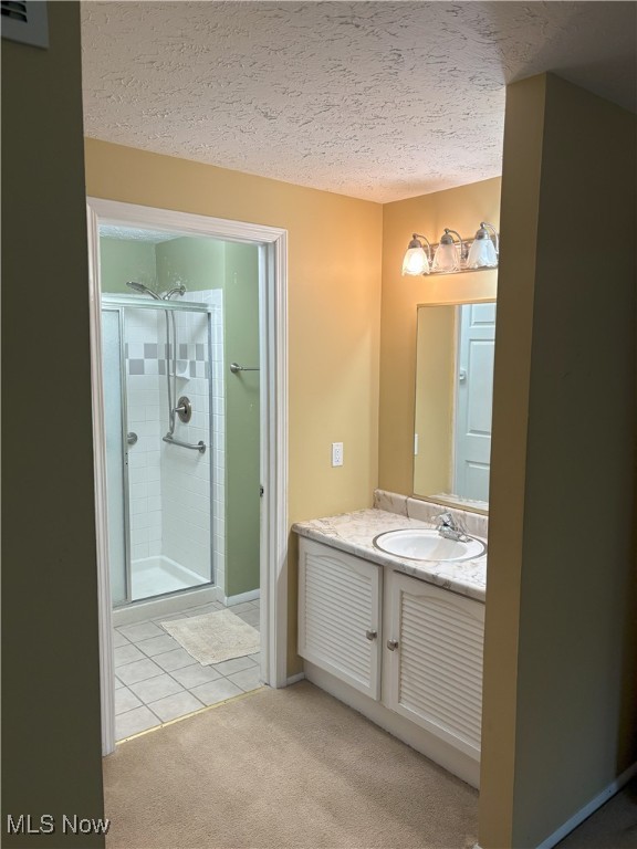 3611 Mark Dr, Broadview Heights, OH 44147 - full bathroom with vanity, a stall shower, a textured ceiling, and tile patterned floors