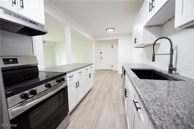8507 Akins Rd Unit C-2, North Royalton, OH 44133 - kitchen with stainless steel electric range oven, under cabinet range hood, tasteful backsplash, white cabinets, and light wood-style flooring