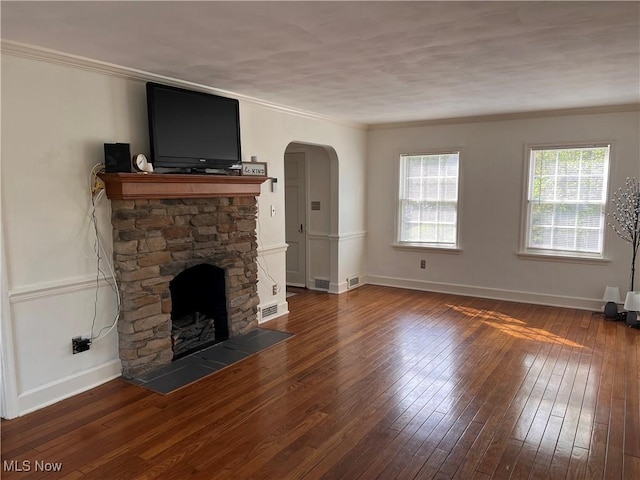 913 Home Cir, Salem, OH 44460 - unfurnished living room featuring a stone fireplace, arched walkways, wood-type flooring, and ornamental molding