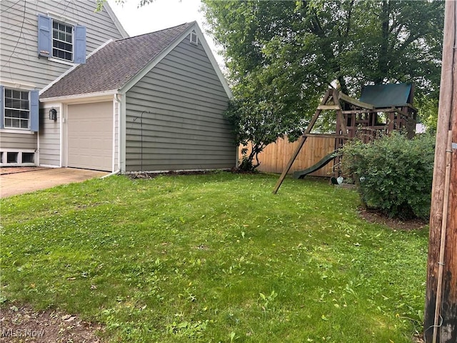 913 Home Cir, Salem, OH 44460 - view of yard with an attached garage, concrete driveway, and a playground