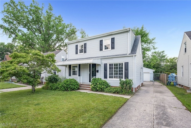 452 E 329th St, Willowick, OH 44095 - traditional-style house with covered porch, a front lawn, an outbuilding, and a detached garage