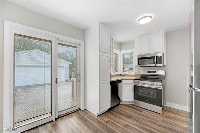 452 E 329th St, Willowick, OH 44095 - kitchen featuring stainless steel appliances, light wood-type flooring, and white cabinets