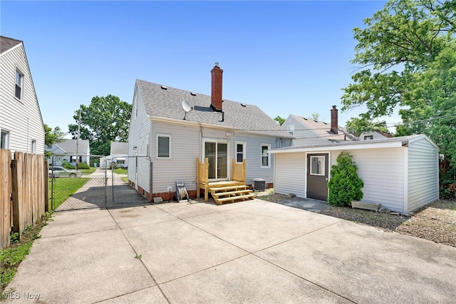 452 E 329th St, Willowick, OH 44095 - back of house featuring a gate, a chimney, a patio, and a shingled roof
