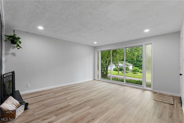 164 Goodview Ave, Akron, OH 44305 - unfurnished living room with light wood-style flooring, recessed lighting, and a textured ceiling