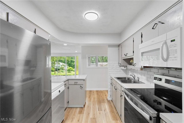 164 Goodview Ave, Akron, OH 44305 - kitchen featuring appliances with stainless steel finishes, light countertops, tasteful backsplash, light wood-type flooring, and a peninsula