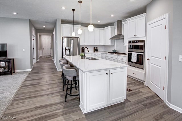 23797 St Andrews Dr, Columbia Station, OH 44028 - kitchen with wall chimney exhaust hood, stainless steel appliances, wood finished floors, a breakfast bar area, and recessed lighting
