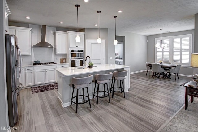 23797 St Andrews Dr, Columbia Station, OH 44028 - kitchen featuring wall chimney range hood, appliances with stainless steel finishes, light wood-style floors, light countertops, and recessed lighting