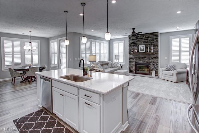23797 St Andrews Dr, Columbia Station, OH 44028 - kitchen with appliances with stainless steel finishes, a textured ceiling, ceiling fan, a large fireplace, and an island with sink