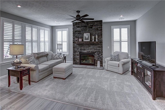 23797 St Andrews Dr, Columbia Station, OH 44028 - living room with plenty of natural light, a ceiling fan, a textured ceiling, wood finished floors, and a large fireplace