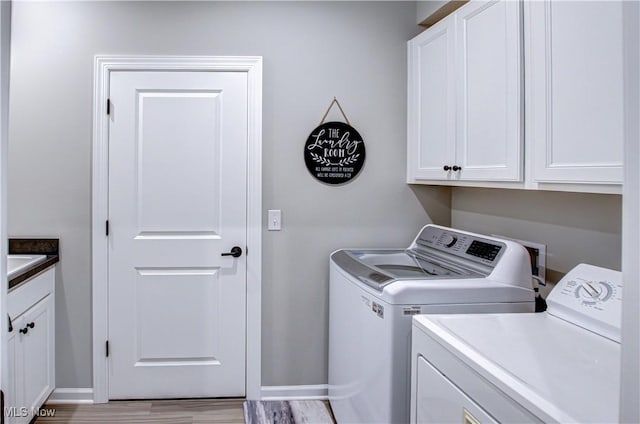 23797 St Andrews Dr, Columbia Station, OH 44028 - washroom featuring washing machine and clothes dryer, cabinet space, and wood finished floors