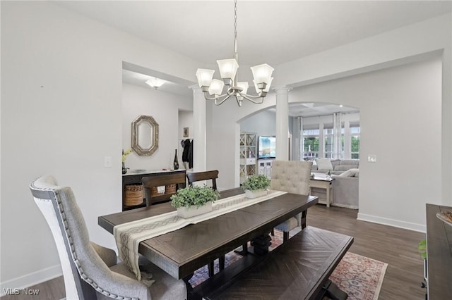 8488 Raya Ln, Streetsboro, OH 44241 - dining room featuring arched walkways, dark wood finished floors, a chandelier, and decorative columns