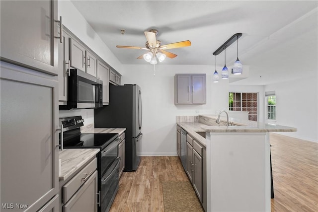 23004 Chandlers Ln Unit 107, Olmsted Falls, OH 44138 - kitchen with stainless steel appliances, a peninsula, gray cabinetry, ceiling fan, and light wood finished floors