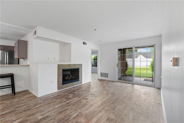 23004 Chandlers Ln Unit 107, Olmsted Falls, OH 44138 - unfurnished living room with wood finished floors and a tile fireplace