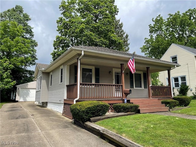 1408 Grant St, Akron, OH 44301 - view of front of home featuring covered porch, an outbuilding, a detached garage, a front lawn, and a shingled roof