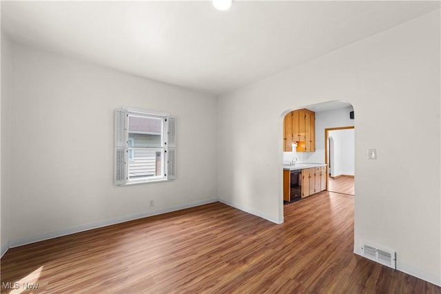 10808 Park Heights Ave, Garfield Heights, OH 44125 - spare room featuring arched walkways and wood finished floors
