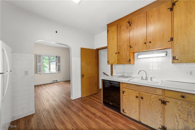 10808 Park Heights Ave, Garfield Heights, OH 44125 - kitchen featuring dishwasher, freestanding refrigerator, wood finished floors, arched walkways, and light countertops