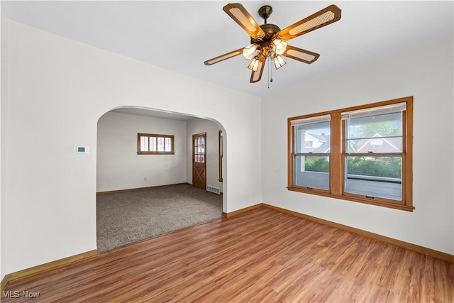 10808 Park Heights Ave, Garfield Heights, OH 44125 - empty room featuring arched walkways, wood finished floors, and ceiling fan