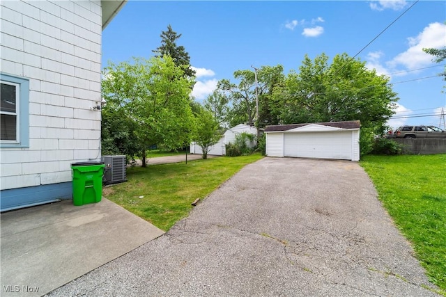 10808 Park Heights Ave, Garfield Heights, OH 44125 - view of green lawn featuring a detached garage and an outbuilding