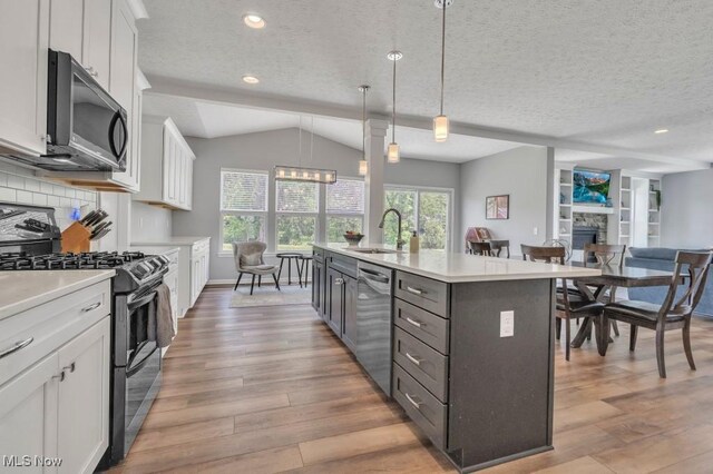 13196 Barrington Dr, Grafton, OH 44044 - kitchen with stainless steel appliances, white cabinetry, light wood finished floors, light countertops, and a textured ceiling
