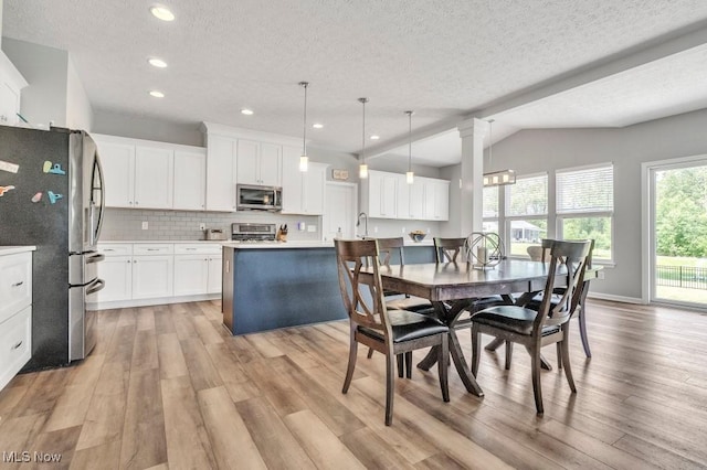13196 Barrington Dr, Grafton, OH 44044 - dining area with light wood-type flooring, a textured ceiling, recessed lighting, and vaulted ceiling