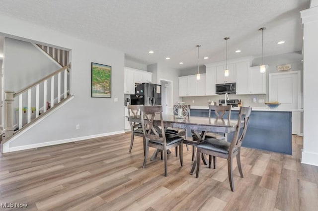 13196 Barrington Dr, Grafton, OH 44044 - dining room with recessed lighting, light wood finished floors, a textured ceiling, and stairway