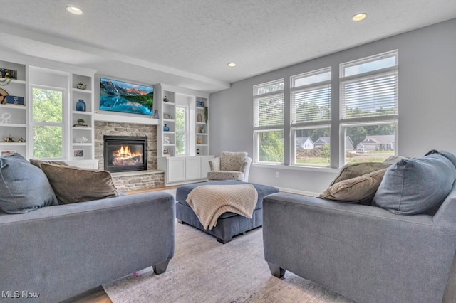 13196 Barrington Dr, Grafton, OH 44044 - living area featuring a textured ceiling, a stone fireplace, recessed lighting, built in features, and carpet flooring