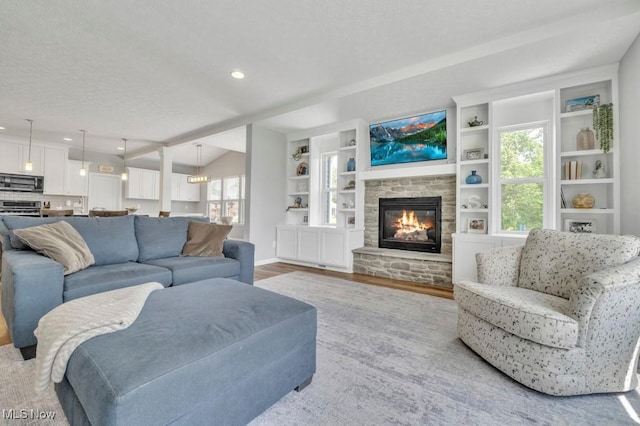 13196 Barrington Dr, Grafton, OH 44044 - living room with wood finished floors, a fireplace, a textured ceiling, vaulted ceiling, and recessed lighting