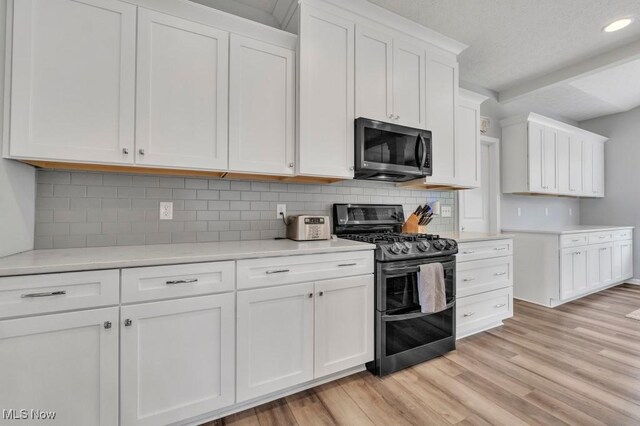 13196 Barrington Dr, Grafton, OH 44044 - kitchen with stainless steel appliances, light countertops, light wood-type flooring, white cabinets, and tasteful backsplash