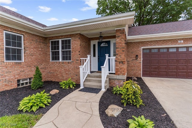 381 Lauretta Ln, Hubbard, OH 44425 - property entrance featuring brick siding, a garage, roof with shingles, and driveway